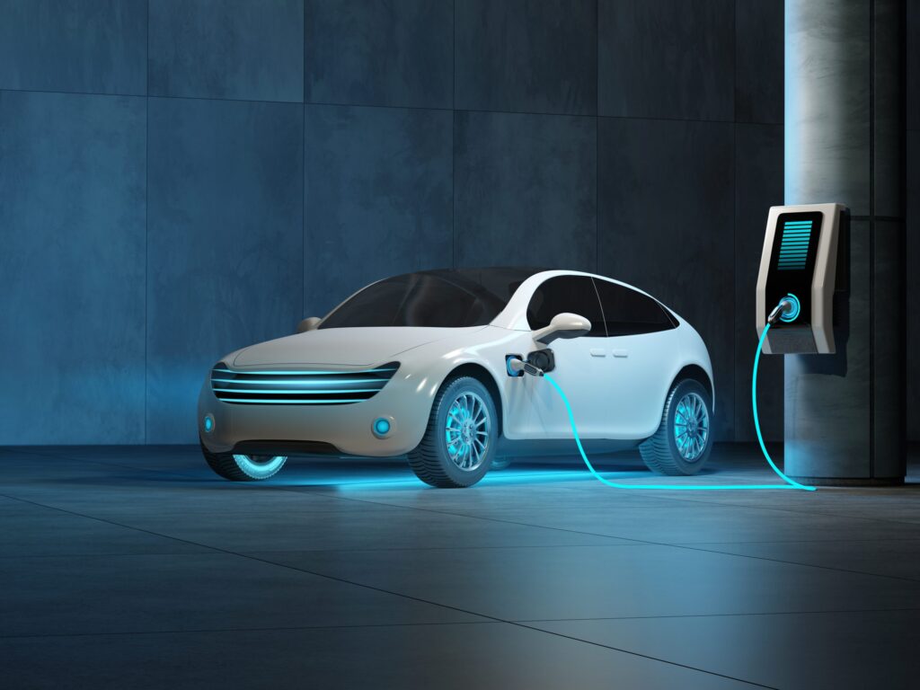 A futuristic electric car is connected to a charging station in the underground parking of the business center
