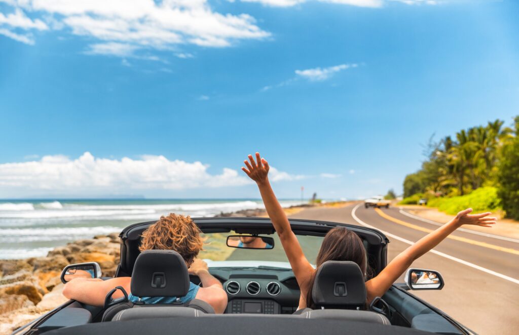 Couple driving convertible car
